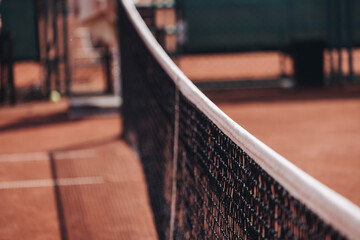 Tennis tournament championship on outdoor clay court with net, professional athletes play in motion with rackets serve tennis ball during tennis match game, tennis training in a sunny day on a stadium