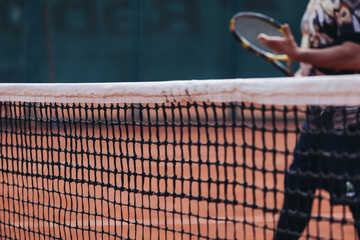 Tennis tournament championship on outdoor clay court with net, professional athletes play in motion with rackets serve tennis ball during tennis match game, tennis training in a sunny day on a stadium