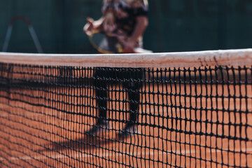Tennis tournament championship on outdoor clay court with net, professional athletes play in motion with rackets serve tennis ball during tennis match game, tennis training in a sunny day on a stadium