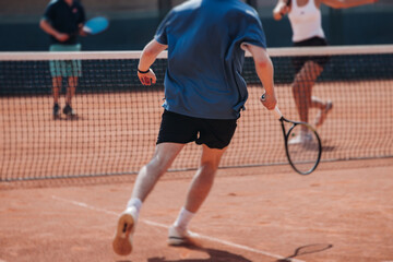 Tennis tournament championship on outdoor clay court with net, professional athletes play in motion with rackets serve tennis ball during tennis match game, tennis training in a sunny day on a stadium