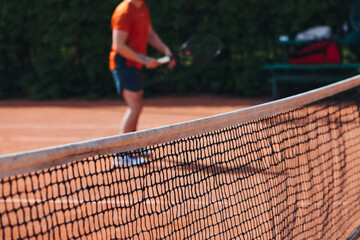Tennis tournament championship on outdoor clay court with net, professional athletes play in motion with rackets serve tennis ball during tennis match game, tennis training in a sunny day on a stadium