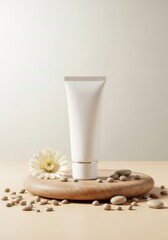 Skincare cream tube displayed on wooden plate with pebbles and flower  