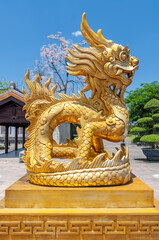Fototapeta premium Golden dragon statue located inside Imperial Royal Palace, Forbidden city in Hue, Vietnam in a summer day.