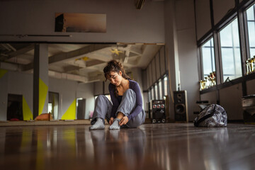 Young woman dancer resting on studio floor