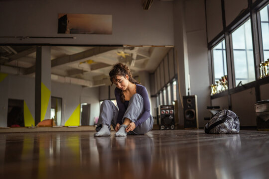 Young woman dancer resting on studio floor