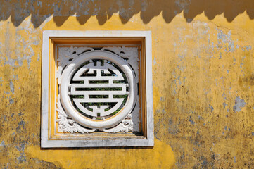 Decorated window in the Imperial City, the  walled enclosure within the citadel of the city of Hue, the former imperial capital of Vietnam.