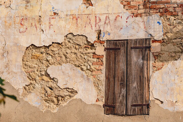 Weathered vintage shop sign on a peeling wall in Cocconato, Piedmont, Italy. The aged lettering and rustic charm highlight the town’s historic character and nostalgic atmosphere