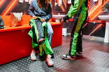 People putting on racing suits in a changing room, getting ready for a fun go karting activity with...