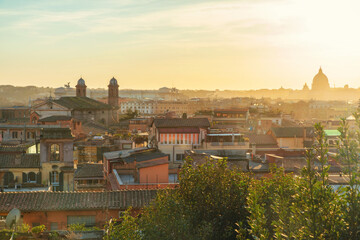 Obraz premium Hazy aerial view of Rome cityscape with historic domes and buildings under soft sunlight at sunrise, viewed from Vatican city, Italy. Popular travel and touristic destination in Europe