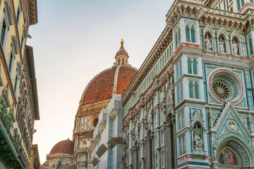 Close up view of Florence Duomo with detailed marble facade and iconic red dome at sunrise, Tuscany, Italy. Dome of Cathedral of Santa Maria del Fiore in Firenze old town. Italian architecture