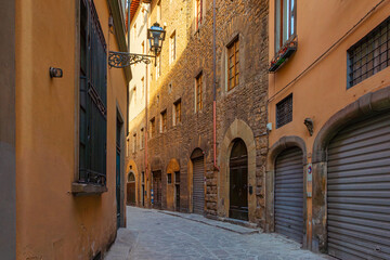 Medieval narrow street in Florence city with Dome of Duomo, colorful buildings and vintage lantern, Tuscany, Italy. Dome of Cathedral of Santa Maria del Fiore in Firenze old town. Italian architecture