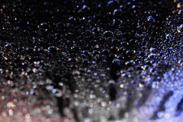 raindrops on a dark background.water drops on glass in close-up. Abstract dark background. Mockup for your logo. horizontal wallpaper or web banner.