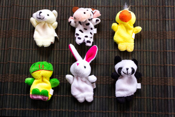 Children's finger puppets on a dark wooden napkin