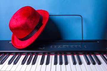 red hat on the piano and blue wall