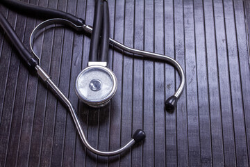 stethoscope on a black wooden surface