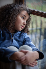Sad Mixed Race African American Girl Looking Out of a Window