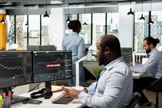 Trader in office receives system hacked warning alert after unauthorized access detected on client trading account. Prop firm worker worried by hacker breaching trading platform account cybersecurity