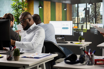 Diverse employees business specialists collaborating in modern office, focusing on project...