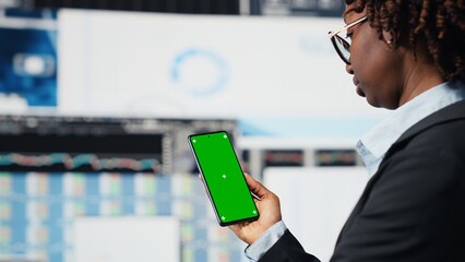 Green screen mockup phone used by manager evaluating business market graphs doing brainstorming....