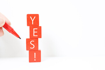 赤いブロックにYESの文字。白背景とコピースペース。