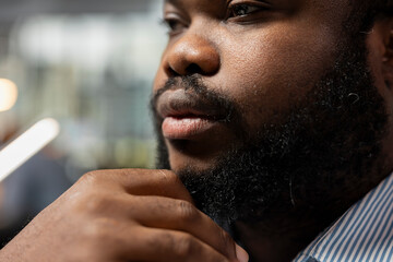 Close up of equity analyst in office reading annual company reports to evaluate stock investment...