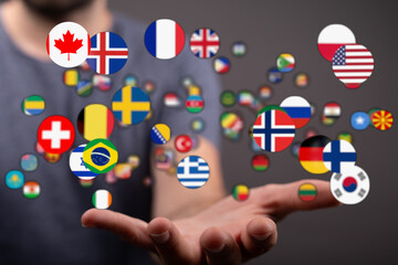 A person's hand holding a collection of flags from different countries, representing global unity, diversity, and international relations. Ideal