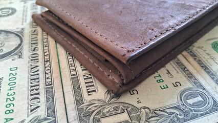Brown Leather Wallet and US Dollar Bills on Green Surface