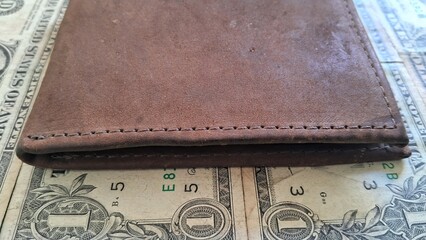 Brown Leather Wallet and US Dollar Bills on Green Surface
