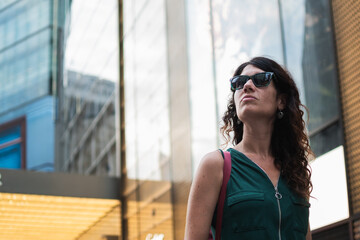 Woman looking up in city street with determination