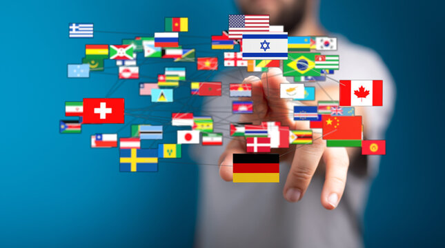 A person's hand connecting flags of different nations, symbolizing global relations and diversity. Represents international collaboration and un