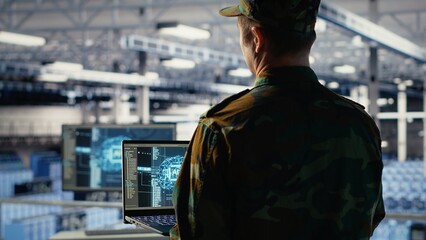Army programmer in high tech server hub uses AI application on laptop to review reconnaissance...
