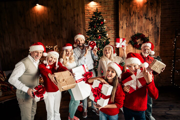 Happy family celebration indoors with Christmas gifts around a decorated tree in a warm cozy living...