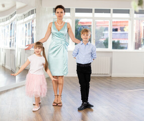 Report shot after series of dance workouts in studio. Female choreography teacher stands next to couple of teen boy and girl students