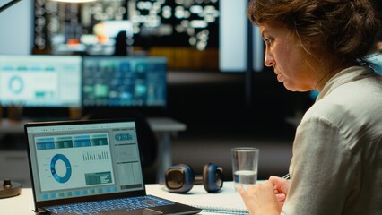 Female finance advisor reviews trading accounts and archived data for future reports, using digital graphs to plan resources allocation and align business goals with financial success. Camera B.