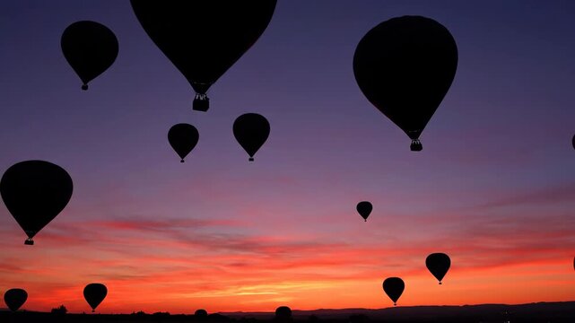 Colorful hot air balloons ascend majestically in silhouette against a breathtaking sunset sky, symbolizing freedom and aspirational childlike dreams serene, dreamlike, scenic