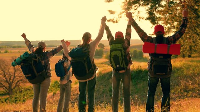 Backpackers raise their hands in celebration. Backpackers travel forest walks outdoor activities. Slow motion. Family, parents, young daughter, travelers, vacation adventures, teamwork. People Hiking
