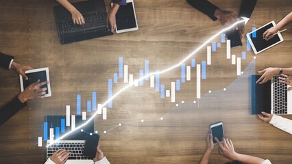 Diverse team collaborates in a modern office setting, analyzing financial data on devices. Graphs illustrate growth, emphasizing strategy and teamwork. Copula