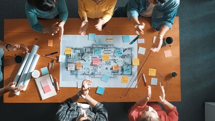 Top down view of business team work together and putting fist together at meeting room. Aerial view of skilled architect engineer making circle from fist. Represented love, unity, teamwork. Symposium.