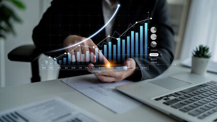 Business professional engages with financial data on a digital device, showcasing growth trends and statistics in a modern office environment. Scalp