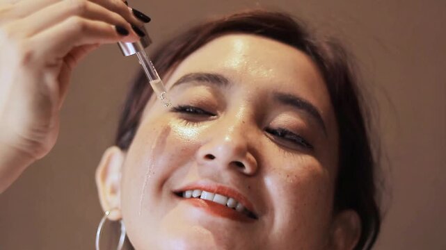 Woman applying face serum with dropper for radiant skin, showcasing skincare routine and healthy complexion, ideal for