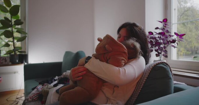 Mother embracing baby by window, serene and emotional moment of affection, motherhood expressing warmth, tenderness and unconditional love in cozy home environment