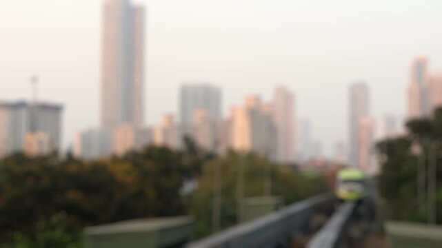 Bokeh view of monorail train arrives at Sant Gadge Maharaj Chowk station in Mumbai, India. Urban cityscape. Blurred background footage.