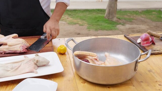 Peruvian chef preparing duck and guinea pig outdoors