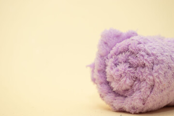 Folded purple towel on beige background