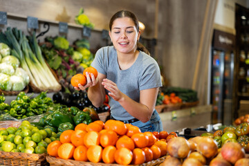 Caucasian woman looking to buy mandarin oranges in local fruit market
