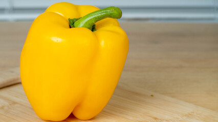 yellow bell peppers on wooden table