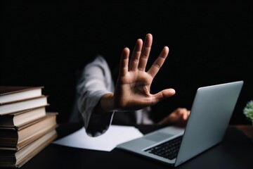 Person using a laptop, showing a palm gesture to symbolize digital protection, internet privacy, or cyberbullying prevention
