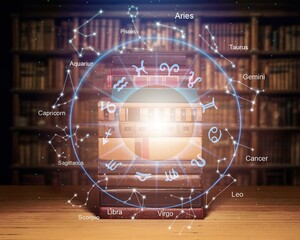 Open book, astrological signs against dark background