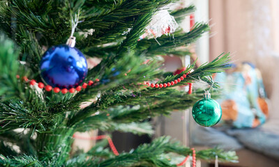Plastic Christmas tree with ornaments and shiny balls hanging from its branches