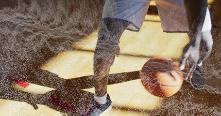 Dribbling man in shorts, socks, sneakers guiding basketball on gym court lines, textured effect